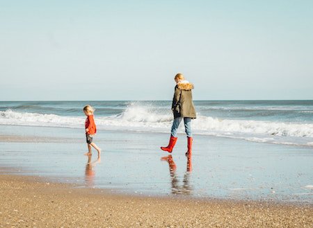 Coast walk - A Lady and child paddling by the sea shore